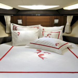 Fish patterned white & red colored sheet set in a modern furnitured sailboat cabin