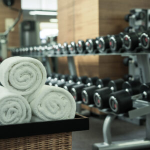 Fitness club in luxury hotel interior. Focus on white towels.